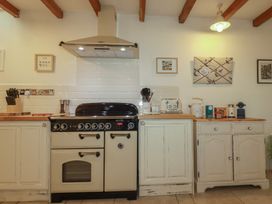 A kitchen with a range cooker and cupboards at Cider Cottage 