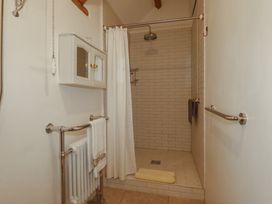A bathroom with a shower and towel rack at Cider Cottage