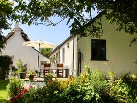 A garden with a table and chairs under an umbrella at Cider Cottage near Launceston