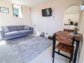 A living room with a sofa and dining table at Coach House in Highampton near Black Torrington