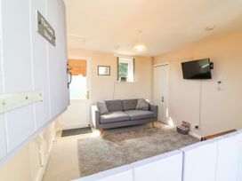 A living room with a sofa and television at Coach House Highampton near Black Torrington