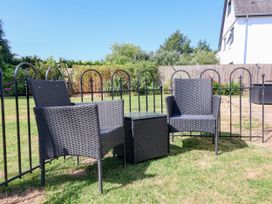 A garden with wicker chairs and table at Coach House Highampton near Black Torrington