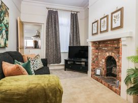 A living room with a sofa and a fireplace at 24 Harrington Road Workington