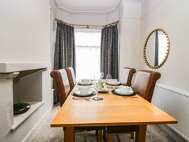 A dining room with a table set for meals at 24 Harrington Road Workington