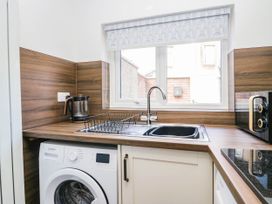 A kitchen with a sink and washing machine at 24 Harrington Road Workington