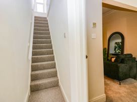 A hallway with stairs and a view of the living room at 24 Harrington Road Workington