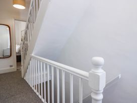 A hallway with a staircase and mirror at 24 Harrington Road Workington