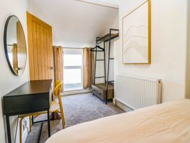 A bedroom with a desk, chair, and clothes rack at 24 Harrington Road, Workington