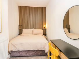 A bedroom with a bed and a dressing table at 24 Harrington Road in Workington