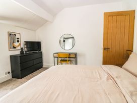 A bedroom with a bed, television, and desk at 24 Harrington Road, Workington