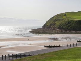 A beach with people walking at 24 Harrington Road in Workington