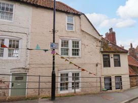 A building with windows and a door with a parking sign at Wick Cottage in Whitby