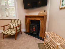 A living room with a fireplace and a chair at Wick Cottage in Whitby