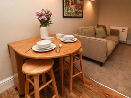 A dining area with a table and stools at Wick Cottage in Whitby