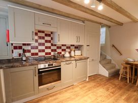 A kitchen with cabinets and appliances at Wick Cottage in Whitby