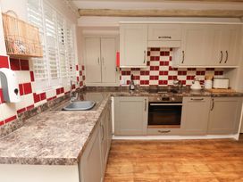 A kitchen with cabinets and appliances at Wick Cottage in Whitby