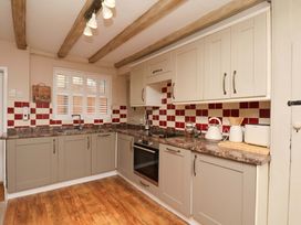 A kitchen with cabinets and appliances at Wick Cottage in Whitby