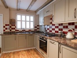 A kitchen with cabinets and appliances at Wick Cottage in Whitby