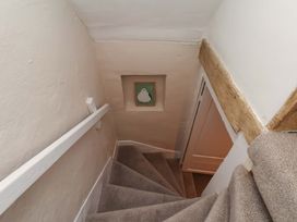 A staircase with a handrail and a wall art at Wick Cottage in Whitby