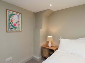 A bedroom with a bed and a side table with a lamp at Wick Cottage in Whitby