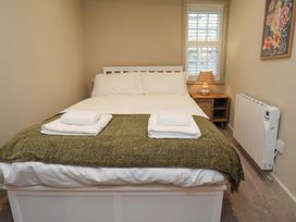 A bedroom with a bed and a lamp at Wick Cottage in Whitby