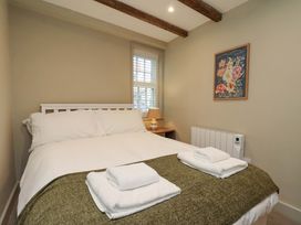 A bedroom with a bed and lamp at Wick Cottage in Whitby