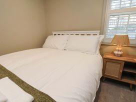 A bedroom with a bed and bedside table at Wick Cottage in Whitby