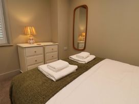 A bedroom with a bed and dresser at Wick Cottage in Whitby