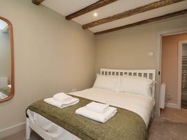 A bedroom with a bed and mirror at Wick Cottage in Whitby