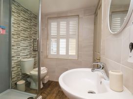 A bathroom with a shower, toilet, and sink at Wick Cottage in Whitby