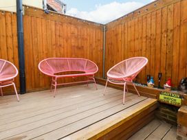 A garden area with wooden flooring and chairs at Wick Cottage in Whitby