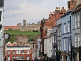 A street view with buildings and ruins in the background at Wick Cottage in Whitby