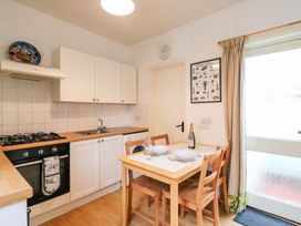 A kitchen with table and chairs at Pixie Cottage in Weymouth