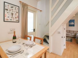 A dining room with a table and chairs at Pixie Cottage in Weymouth