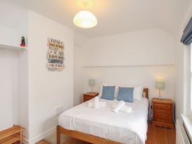 A bedroom with a bed and bedside tables at Pixie Cottage in Weymouth