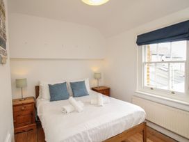 A bedroom with a bed and nightstands at Pixie Cottage in Weymouth