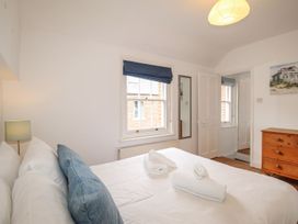 A bedroom with a bed and a chest of drawers at Pixie Cottage in Weymouth