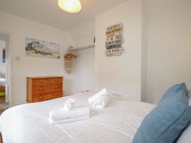 A bedroom with a bed and chest of drawers at Pixie Cottage in Weymouth
