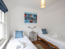 A bedroom with two single beds and a side table at Pixie Cottage in Weymouth
