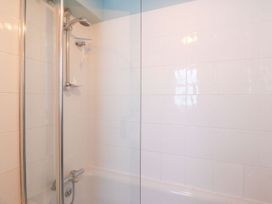 A shower with bathtub in a bathroom at Pixie Cottage in Weymouth