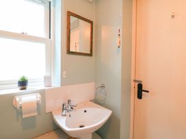 A bathroom with a sink and mirror at Pixie Cottage in Weymouth
