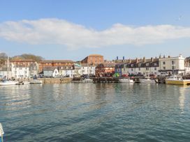 A waterfront view with buildings and boats at Pixie Cottage in Weymouth