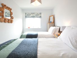 A bedroom with two beds and a mirror at Lapwings, Aldeburgh