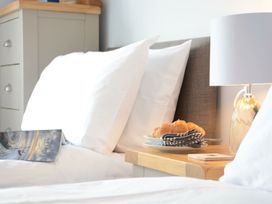 A bedroom with a bed and croissants on a plate at Lapwings, Aldeburgh