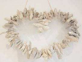 A circular driftwood decoration hanging on a wall at Lapwings, Aldeburgh