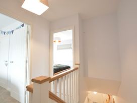 A hallway with staircase and doors at Lapwings, Aldeburgh