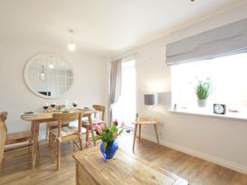 A dining room with a table set and a lamp at Lapwings, Aldeburgh