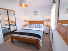 A bedroom with a bed and bedside tables at Lapwings, Aldeburgh