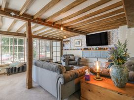 A living room with a sofa, coffee table, and television at The Annex in Cavendish Near Sudbury