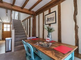 A hallway with a staircase and dining table at The Annex Cavendish Near Sudbury